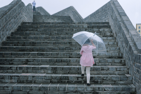child take Umbrella walking on stairsの写真素材