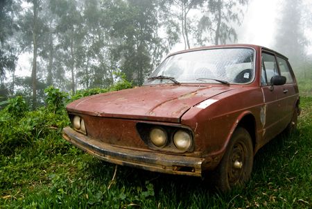 Brown old car abandoned in rural landscape with mist.の写真素材