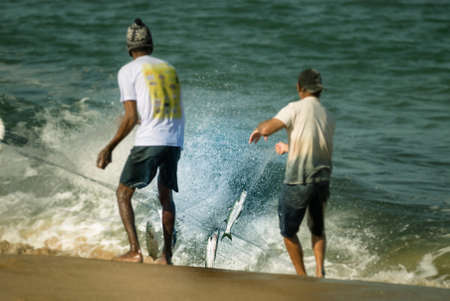 BalneÃ¡rio CamboriÃº/Santa Catarina/Brasil - 05 29 2020: Mullet fishermen pulling a fishnet on a beach on the south coast of Brazil.のeditorial素材