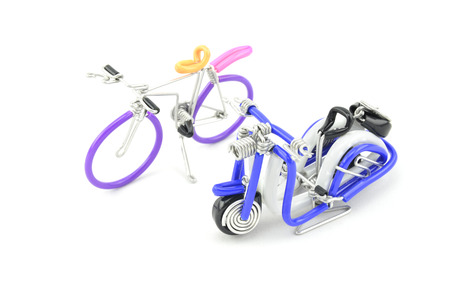 wired purple miniature bicycle and blue scooter placed side by side isolated white backgroundの写真素材