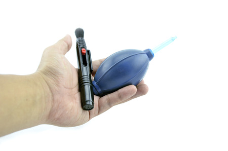lens pen and blue air blower on hand isolated white background