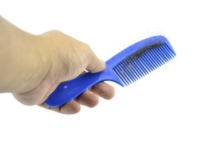 hand holding blue comb contain hairfall  isolated white backgroundの写真素材