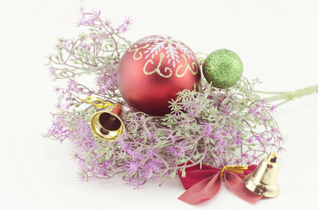group image of Christmas decorations with red ball,green ball,red ribbon,bell and artificial flower isolated on white backgroundの写真素材