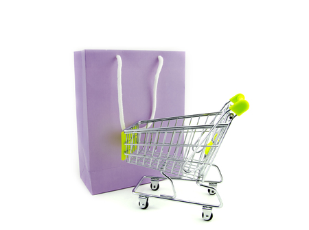 purple paper bag with shopping trolley isolated white backgroundの写真素材