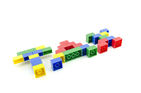 word TAX built from colorful building blocks isolated on white background