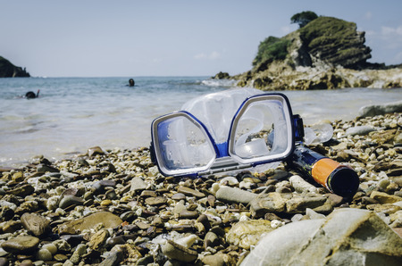 retro look concept, image of Diving Goggles and Snorkel Gear on stone at sunny day