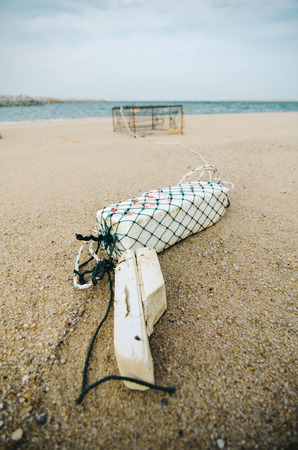 white fish buoy on sandy beach over crab pot background.focus on white buoy.shallow depth of fieldの写真素材