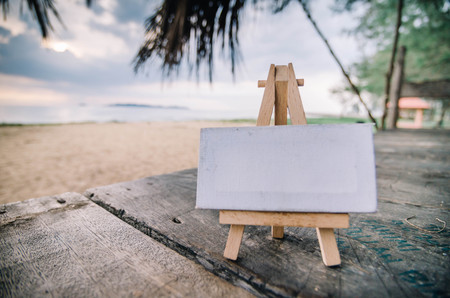 white canvas frame and wooden easel under cottage and blurred backgroundの写真素材