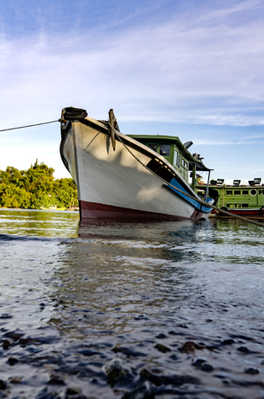fisherman boat anchored over cloudy and blue sky background at sunny dayの写真素材
