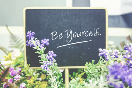 conceptual image, word BE YOURSELF on wooden blackboard. blurred background and faded color tone effectの写真素材