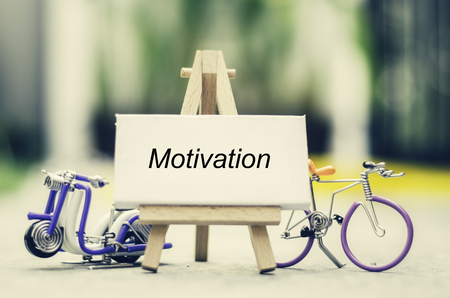 Inspiration quote  " motivation" with blur bokeh, easel,wired handcrafted scooter and bicycle background ,Motivational typographic.の写真素材