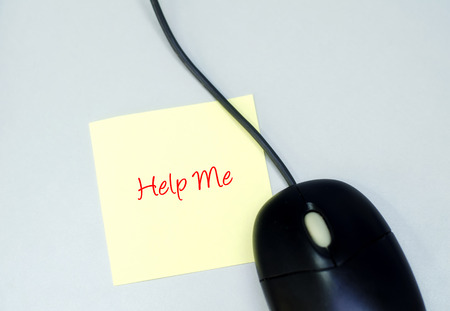 Help Me word on yellow sticky paper over white table surface and mouse.の写真素材
