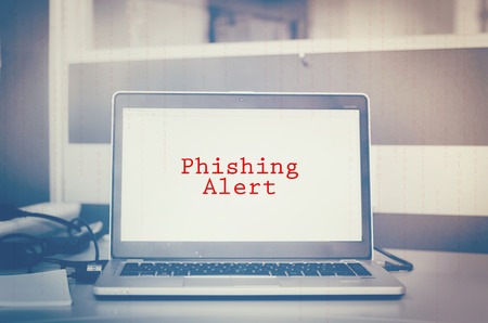 Red word, phishing alert on laptop screen. binary code and blurred background. cyber security metaphor conceptの写真素材