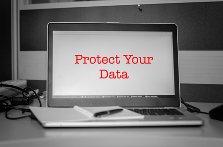 cyber security concept. red word protect your data display on laptop screen.Black and white image and selective focusの写真素材