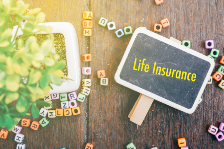 Word LIFE INSURANCE for protection beneficiary safeguard concept.fake lighting effect and wooden backgroundの写真素材