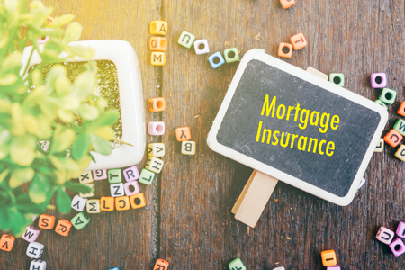 Word MORTGAGE INSURANCE for protection beneficiary safeguard concept.fake lighting effect and wooden backgroundの写真素材