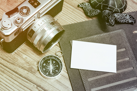 Business travel concept image, top view name card on personal planner book, vintage camera,compas and wooden floor backgroundの写真素材