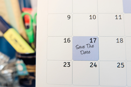 handwriting word save the date on calendar over blurred background.selective focus shotの写真素材