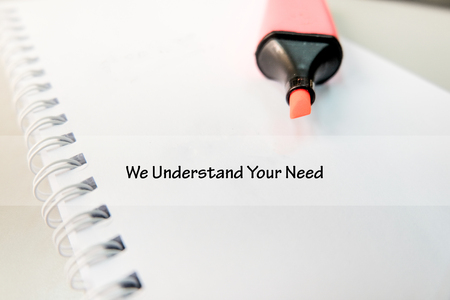 word WE UNDERSTAND YOUR NEED on white book with highlighter pen ideal for business success conceptの写真素材
