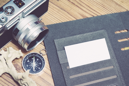 Business travel concept image, top view name card on personal planner book, vintage camera and wooden floor backgroundの写真素材