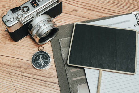 Business travel concept image, personal planner book, vintage camera and wooden floor backgroundの写真素材