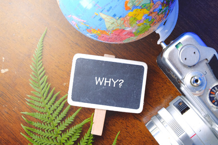 Word WHY for customer service and support concept with flat lay globe,camera and fern leaf on wooden tableの写真素材