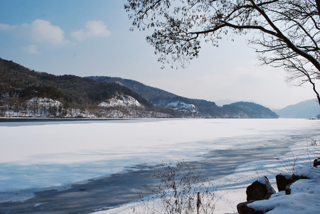 Beautiful nature,park covered by snow and freezing lake during winter at sunny dayの写真素材