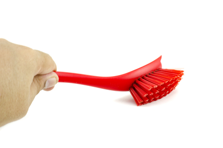 cropped image, hand holding red placstic brush isolated on white backgroundの写真素材