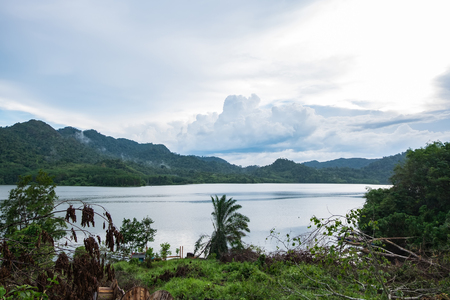 beautiful nature, lake surrounded by hill over cloudy sky backgroundの写真素材