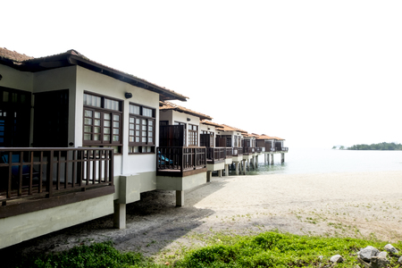 Travel holiday attraction, wooden modern design hotel on water over cloudy sky background.の写真素材