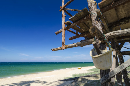 tropical sea view under wooden hut at sunny day. sandy beach and blue sky backgroundの写真素材