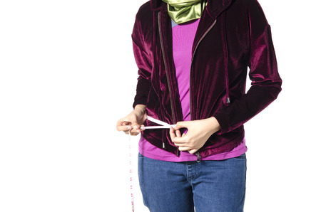 Young girl measuring her waistline with measure tape ideal for Weight loss, slim body, healthy lifestyle concept isolated on white background.copysapce to the left for textの写真素材