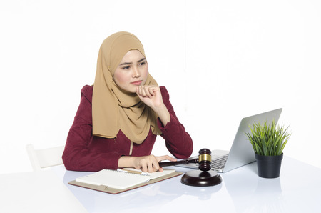 Business and consultation concept,thinking face businesswoman with hijab sitting.book and laptop with reflectionの写真素材