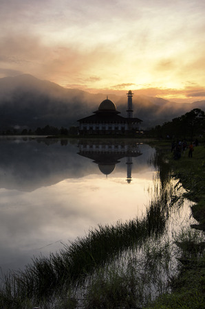Beautiful morning near the lake, fog cover the hill, reflection and lightiing from the mosqueの写真素材