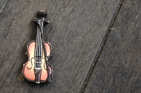 Music passion and hobby concept, violin miniature on wooden floor with retro color tone.copy space...