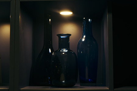 low light shot image of bottles display on rack.shadow and light conceptの写真素材