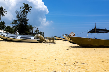 Beauty in nature,fisherman boat stranded on deserted sandy beach under bright sunny day and blue sky backgroundの写真素材