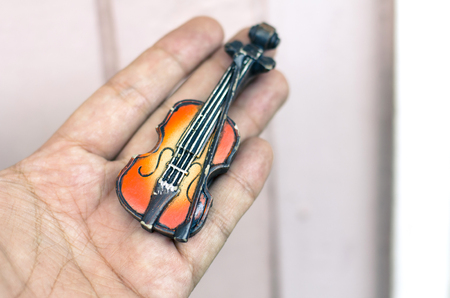 Music passion and hobby concept, hand holding violin miniature.copy space on the right for textの写真素材