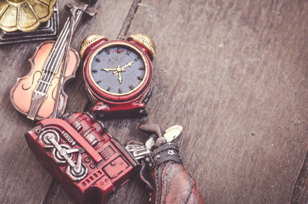 hobby and leisure object concept, miniature violin, clocks,golf sets, train and gramaphone on wooden floorの写真素材
