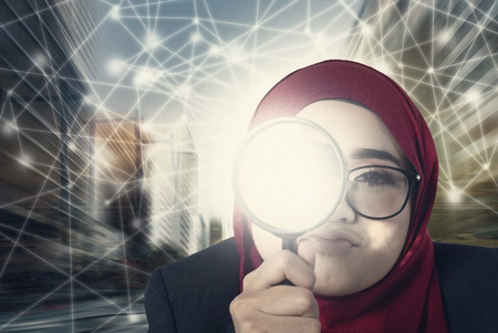 frustrated expression, businesswomen keep searching using her magnifier over abstract connection line backgroundの写真素材