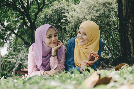 Outdoor lifestyle, friendship and happiness concept. portrait of smile young women laying on grassの写真素材