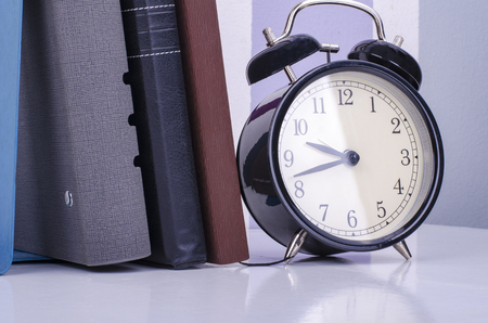 vintage clock and diary on table over colorful background wall. の写真素材