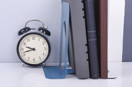 vintage clock and diary on table over colorful background wall. の写真素材