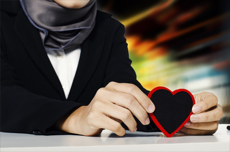 valentine and romance concept,cropped image young women holding love symbol over abstract backgroundの写真素材