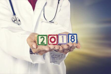 Healthy lifestyle for new year, crop image hand holding wooden block with year 2018