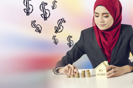 Creative ideas concept, successful young muslimah  saving money for her dream house over abstract double exposure backgroundの写真素材
