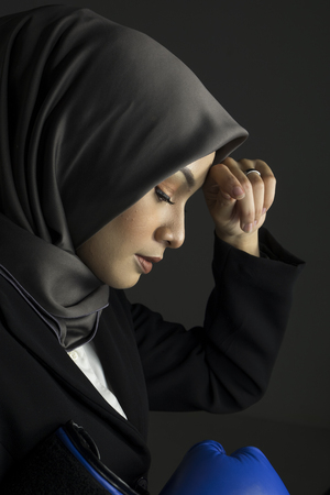 Portrait of tired and distress expression young grinning professional woman wearing boxing gloveの写真素材