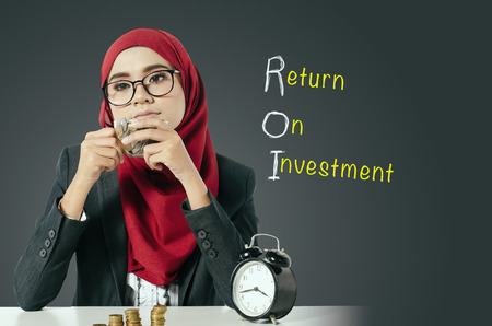 Young woman holding cup of coins with thinking expression face for Return On Investment conceptの写真素材