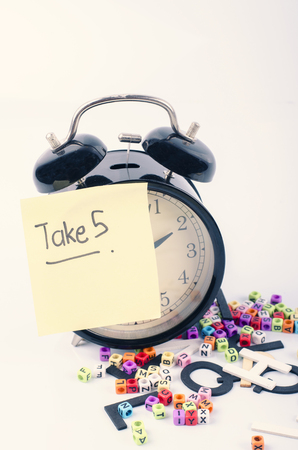 hand writing word of TAKE 5 written on sticky paper over white backgroundの写真素材