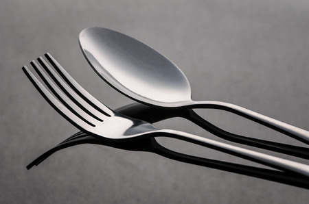 fork and silver spoon on dark background
